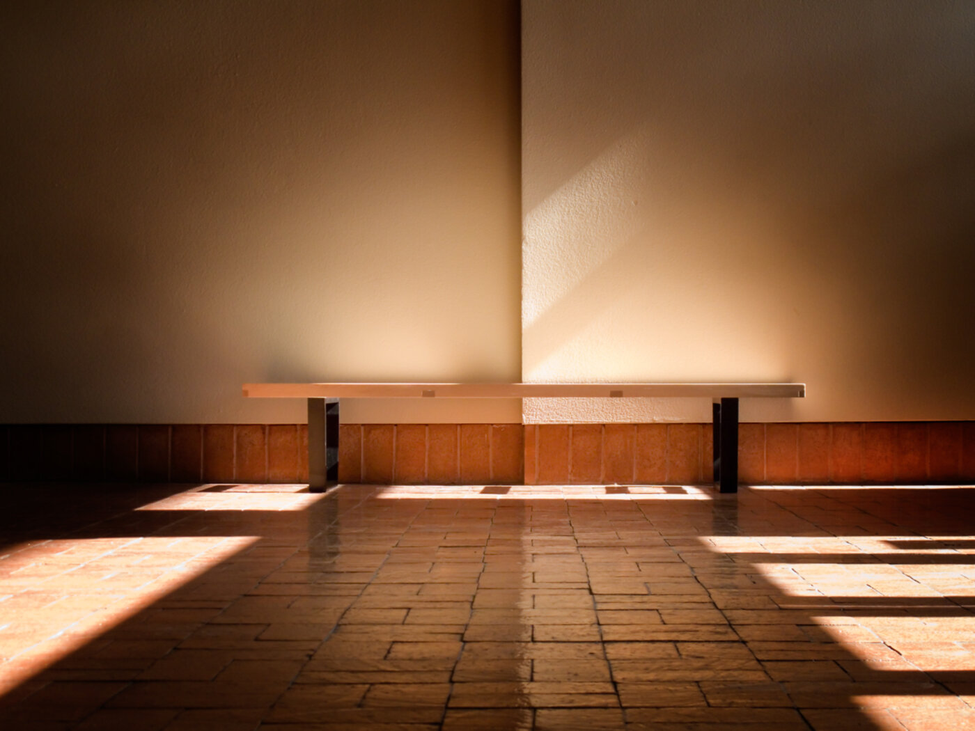 Een houten bankje in zacht middaglicht — een rustig moment om even te zitten.